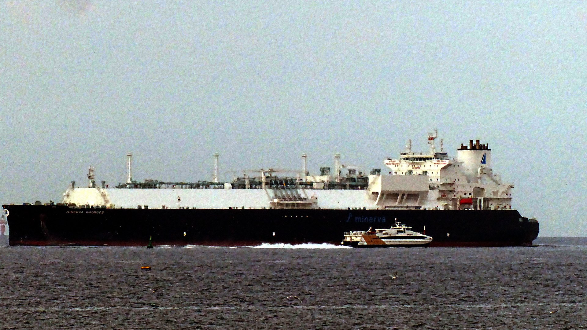 An LNG carrier under way with a pilot boat alongside